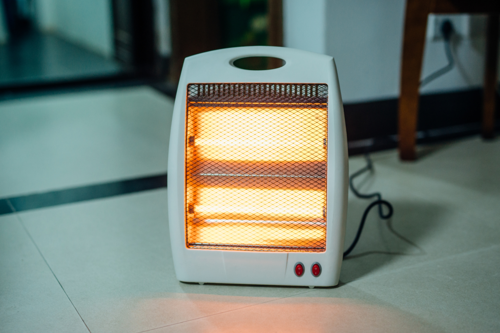 Portable electric space heater operating indoors, providing supplemental heating in a room.